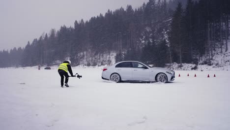 Person-use-gimbal-camera-stabilization-to-film-countryside-winter-drift-event