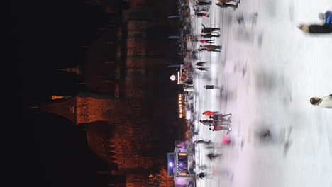 Ice-skaters-at-City-Park-Ice-Rink-by-Vajdahunyad-Castle,-vertical-timelapse