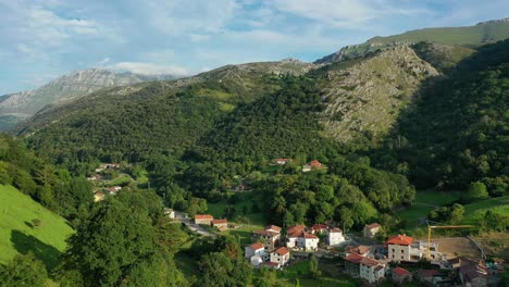 Flug-In-Einem-Kleinen-Und-Engen-Tal-In-Einem-Dorf-Mit-Wiesen-Für-Feldfrüchte-Und-Vieh-Mit-Grünem-Gras-Vor-Dem-Hintergrund-Eines-Kalksteinbergs-Mit-Blauem-Himmel-Mit-Wolken-In-Kantabrien-Spanien