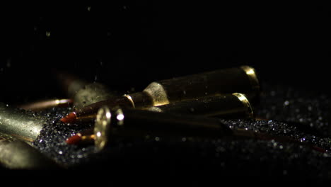 Detail-macro-shot-of-bullet-falling-on-pile-of-gunpowder,-tilt-down,-close-up