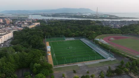 Aerial-Drone-Fly-Panoramic-Campus,-Soccer-Field-with-Players-at-Football-Match,-School-in-Fukui-City-Japan