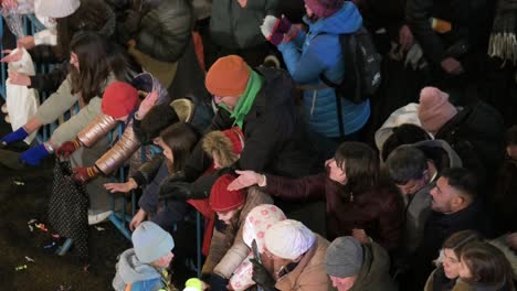 Attendees-catch-candies-thrown-by-parade-floats-at-the-Three-Wise-Men,-also-known-as-the-Three-Kings-Parade