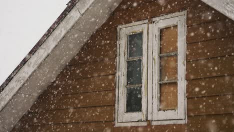 Schneeflocken-Fallen-Vor-Dem-Fenster-Eines-Dachgeschosses-In-Gulmarg,-Kaschmir,-Indien---Nahaufnahme