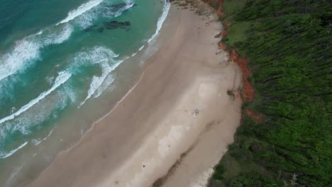 Foamy-Waves-Splashing-On-The-Sandy-Shore-Of-Broken-Head-Beach-In-NSW,-Australia---Aerial-Shot