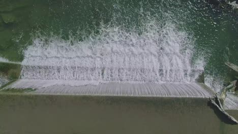 An-Aerial-Downward-View-of-a-Man-Made-Waterfall-for-a-Mill,-on-a-Sunny-Day