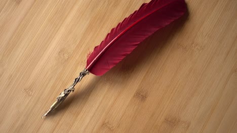 Feather-Pen-on-Wood-Background-Rotates