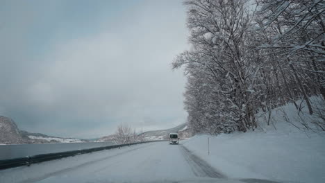 POV-Video-Einer-Fahrt-Bei-Tageslicht-Durch-Die-Verschneiten-Straßen-Der-Westlichen-Fjorde-Norwegens,-Umgeben-Von-Hohen,-Schneebedeckten-Bergen-Mit-Bäumen