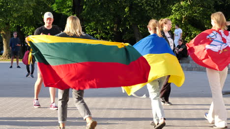 Europäische-Frauen-Tragen-Flaggen-Von-Litauen-Und-Der-Ukraine-Während-Des-NATO-Gipfels-In-Vilnius,-Litauen