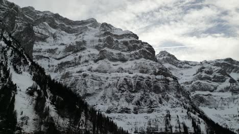 Klöntalersee-Switzerland-Glarus-aerial-of-mountain-tops-upwards-view-sideways-flight