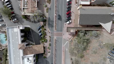 Downtown-Sedona,-Arizona-street-with-cars-driving-and-drone-video-overhead-looking-down-stable