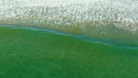 Drohnenaufnahmen-Folgen-Den-Wellen,-Die-Auf-Den-Strand-Krachen