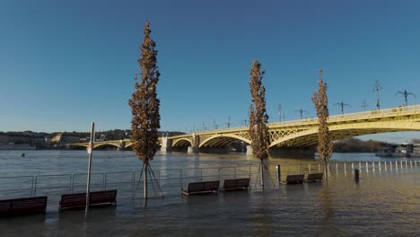 River-Danube-Flooding-at-Margaret-Bridge,-Trees-and-Public-Benches-under-water-at-Budapest,-Hungary---December-28,-2023