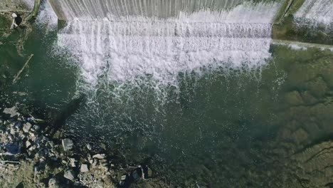 Eine-Luftaufnahme-Von-Unten-Auf-Einen-Künstlichen-Wasserfall-Für-Eine-Mühle-An-Einem-Sonnigen-Tag