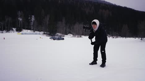 Videographer-hold-gimbal-camera-stabilization-equipment,-winter-drift-event