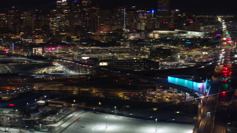 Denver-downtown-Colfax-i25-highway-traffic-aerial-drone-snowy-winter-evening-dark-night-city-lights-landscape-skyscraper-Colorado-cinematic-anamorphic-pan-up-reveal-forward-motion