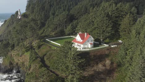 Drone-rises-over-the-Haceta-Head-assistant-lightkeeper's-house-in-Oregon