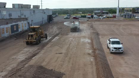 Workers-using-heavy-machinery-to-level-the-ground-for-parking-lot-construction