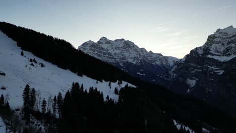Fronalpstock-Switzerland-Glarus-Swiss-alps-flight-over-dark-forest-reveal-mountain-beauty