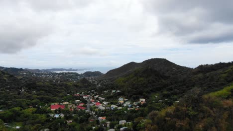 Overlooking-a-lush-Grenadian-rainforest-with-scattered-houses-and-a-glimpse-of-the-sea