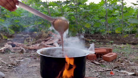 A-man-cooks-chai-tea-over-an-open-flame-on-a-farm-in-India