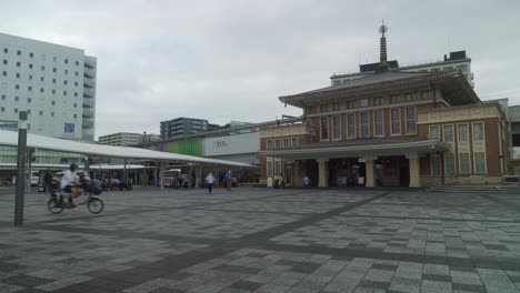 Blick-Auf-Den-Bahnhof-Jr.-Nara-An-Einem-Bewölkten-Tag-Mit-Vorbeifahrenden-Radfahrern