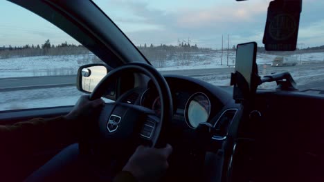 Inside-of-a-car-with-steering-wheel-on-highway-in-winter