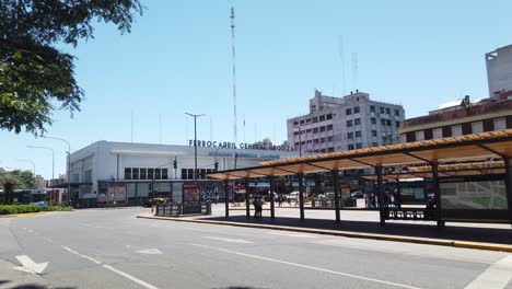 Alter-LKW-Fährt-Am-Bahnhof-Federico-Lacroce-In-Buenos-Aires,-Argentinien,-Vorbei,-Straßenwahrzeichen,-Busse,-Autos-Und-Verkehr-Auf-Der-Avenue-In-Argentinien,-Plaza-Los-Andes,-Chacarita