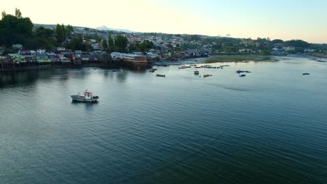 Vogelperspektive:-Aufbau-Der-Castro-Stelzenhäuser-Auf-Der-Insel-Chiloé-Mit-Möwen-Und-Fischerbooten-Am-Ufer,-Sonnenuntergang-Im-Süden-Chiles