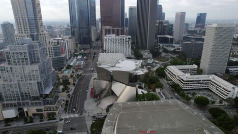 Aerial-View,-Walt-Disney-Concert-Hall-and-LA-Opera-House-in-Downtown-Los-Angeles-CA-USA,-Revealing-Drone-Shot-of-Central-Skyscrapers