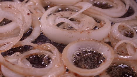 Full-frame-closeup:-Onion-rings-fry,-sizzle-in-hot-oil-in-frying-pan