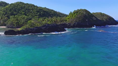 Scenic-drone-flight-along-rocky-coastline-of-the-Dominican-Republic,-blue-ocean