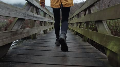 Señorita-En-Cámara-Lenta-Cruzando-Un-Puente-Peatonal-De-Madera-Sobre-Un-Vapor-En-El-Campo