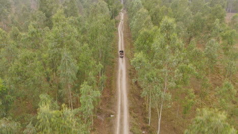 Drone-shot-of-a-Carriage-Truck-traveling-inside-green-forest-of-Terai-region-of-Nepal-to-Kathmandu