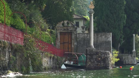 Älteres-Paar-Betrachtet-Ein-Boot,-Das-In-Der-Nähe-Der-Küste-Von-Varenna-Schwimmt