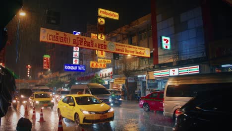 Tráfico-De-Bangkok-Bajo-La-Lluvia-Por-La-Noche-Con-Tiendas-Y-Luces-De-Neón-En-Chinatown