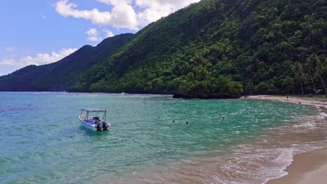 Verankertes-Motorboot-Und-Schwimmende-Menschen-Im-Klaren-Karibischen-Meerwasser-Während-Des-Urlaubs