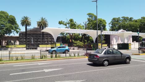 Traffic-Drives-By-Chacarita-Cemetery,-Summer-Skyline-Landmark-Federico-Lacroce-Avenue-at-the-Capital-Famous-Barrio,-Urban-Neighborhood-at-South-America,-Buenos-Aires-City-Argentina