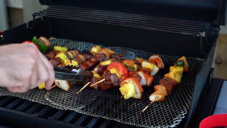 Schaschlikspieße-Auf-Dem-Grill,-Kaukasisches-Hähnchen,-Steak,-Ananas-Spieße-Mit-Einer-Zange-Von-Hand-Wenden