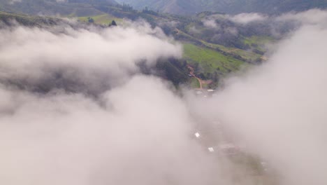 Tiro-Inclinado-Hacia-Abajo-Desde-Majestuosas-Nubes-Sobre-La-Hermosa-Ciudad-De-Oxapampa,-Perú