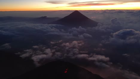 Órbita-Aérea-Sobre-Los-Volcanes-De-Guatemala-Al-Amanecer,-Revelando-El-Brillante-Cráter-Lleno-De-Lava-De-Fuego-Durante-La-Vibrante-Hora-Dorada-Justo-Antes-Del-Amanecer.