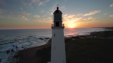 Sunset-view-of-Farol-lighthouse-in-Portugal-with-ocean-waves,-aerial-shot