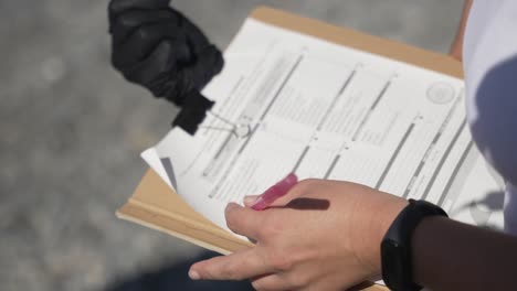 Close-up-of-hands-of-a-scientist-fills-out-an-official-scientific-form-related-to-climate-change