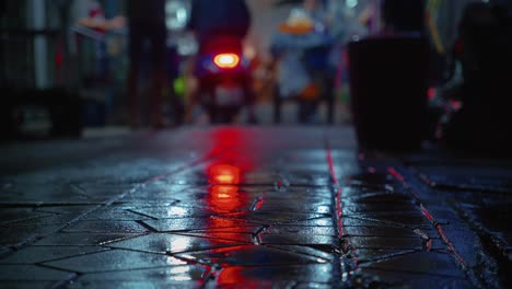 Roller-Mit-Roter-Hintergrundbeleuchtung-Reflexion-Auf-Nasser-Straße-In-Einem-Nachtmarkt-In-Bangkok