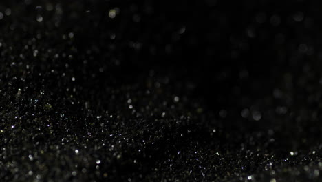 Macro-closeup-of-shiny-dark-black-gunpowder,-detail-shot,-background