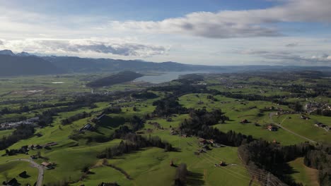 Establish-shot-Aerial-green-field-nature-over-village-houses-Switzerland