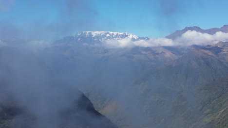 Toma-Aérea-De-Grúa:-Montañas-Nevadas-Y-Valles-Verdes-En-La-Nube