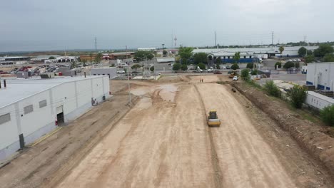 Road-roller-compacting-the-ground-for-parking-lot-construction