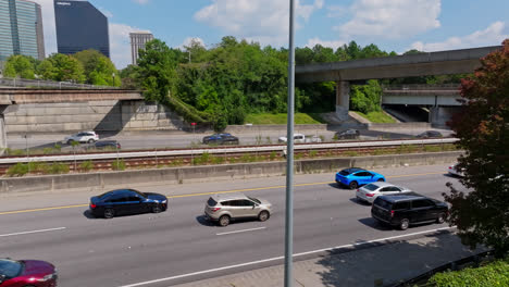 Coches-Americanos-Circulando-Lentamente-Por-La-Autopista-Americana-En-La-Ciudad-De-Atlanta-Durante-El-Día-Soleado.