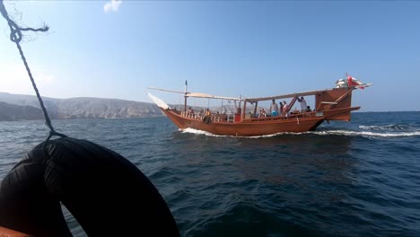View-of-the-waves-hitting-the-dhows-in-the-Khasab-sea,-tourists-taking-a-boat-tour-in-the-sea