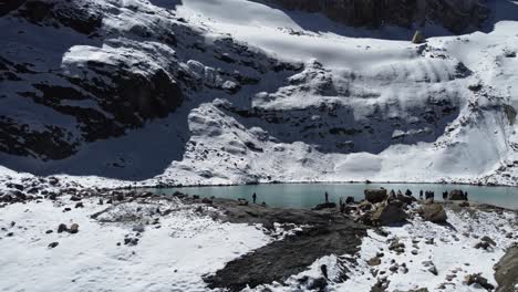 Aerial:-Tourists-visit-Laguna-Charquini-in-snowy-mountains-of-Bolivia